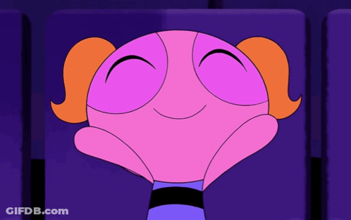 Bubbles From The Powerpuff Girls Is Smiling While Sitting In A Theater Seat GIF