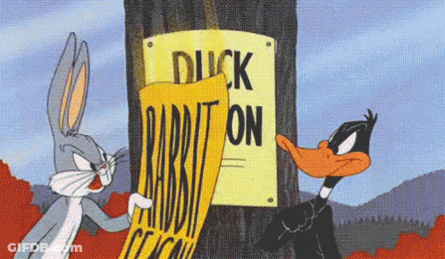 Bugs Bunny And Daffy Duck Standing Next To Duck Rabbit Sign GIF