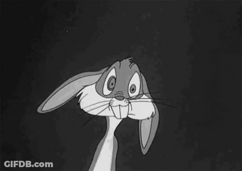 Bugs Bunny From The Looney Tunes Cartoon Is Sitting Down With His Hands Folded In Front Of His Face . GIF