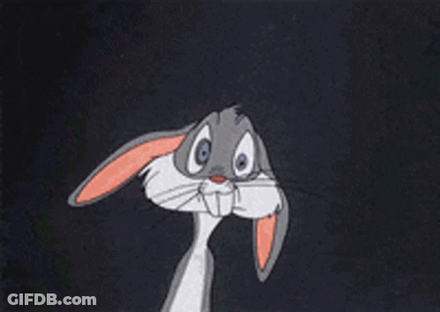 Bugs Bunny Is Sitting Down With His Hands Folded In Front Of Him GIF