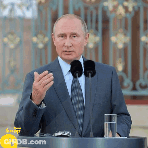 Businessman At Podium With Two Microphones And Water GIF