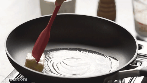 Butter Being Stirred In Frying Pan With Red Spatula GIF