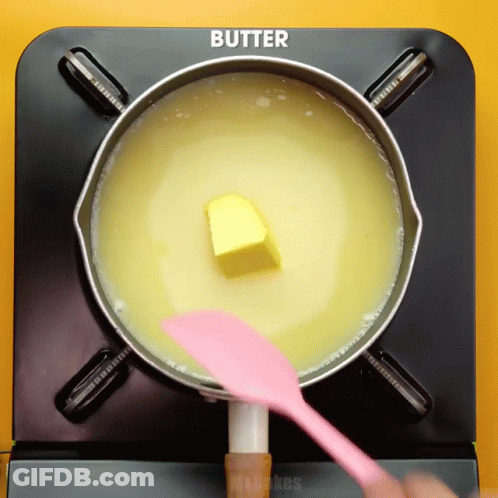 Butter Is Being Stirred In A Pot With A Pink Spatula GIF