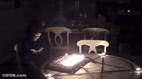 Cake With Candles On Table In Dark GIF