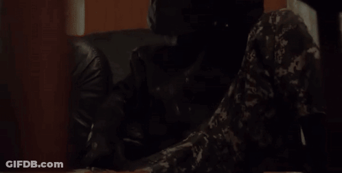 Camouflage Man Sitting At Table With Gun GIF