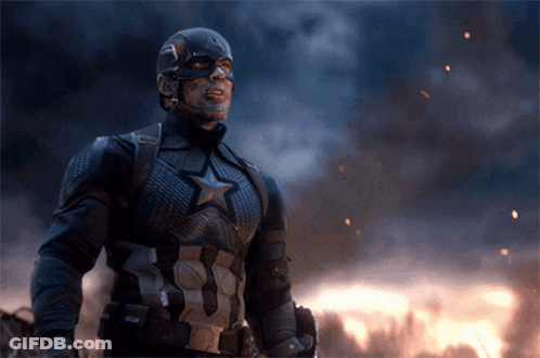 Captain America Is Standing In Front Of A Fire And Smoke GIF