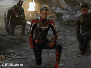 Captain Marvel Is Kneeling Down In Front Of A Group Of Men In Avengers : Age Of Ultron . GIF