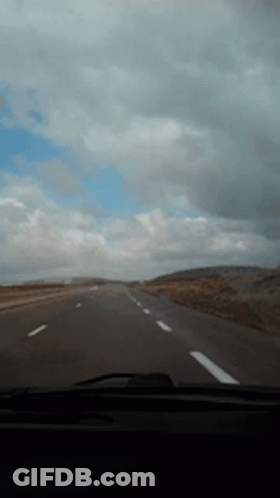 Car Driving Down Highway With Cloudy Sky GIF
