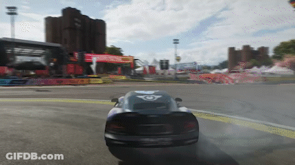 Car Driving Down Road With Building And Hot Air Balloon GIF