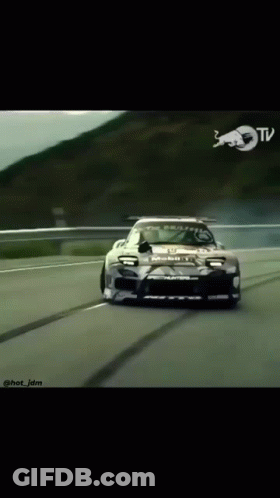 Car Driving Down Road With Red Bull Logo GIF
