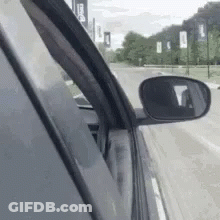 Car Driving Down Street With Rear View Mirror GIF