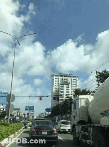 Car Driving Past Large Building GIF