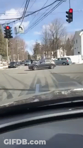 Car Driving Through Busy Intersection With Red Light GIF