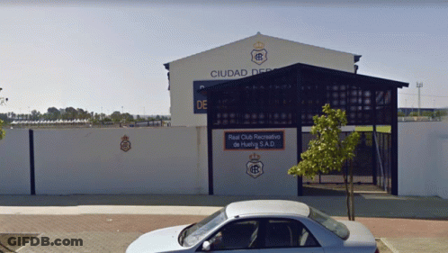 Car Parked In Front Of Building Saying Ciudad GIF