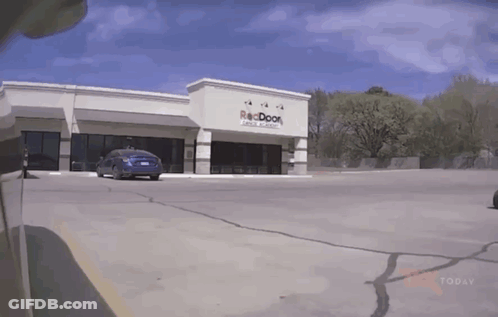Car Parked In Front Of Reddoor Building GIF