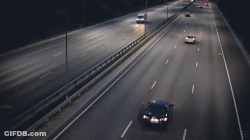Cars Are Driving Down A Highway At Night And One Of Them Is A Yellow Car GIF