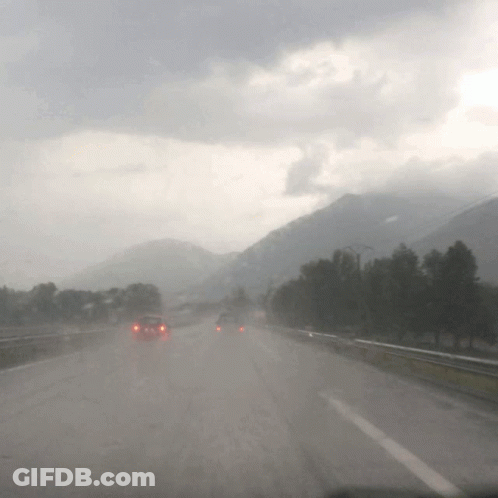 Cars Are Driving Down A Highway In The Rain GIF