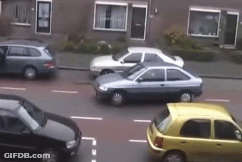 Cars Driving Down Street Including Yellow One GIF