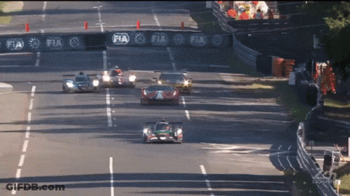 Cars Racing On Track With FIA Banner GIF