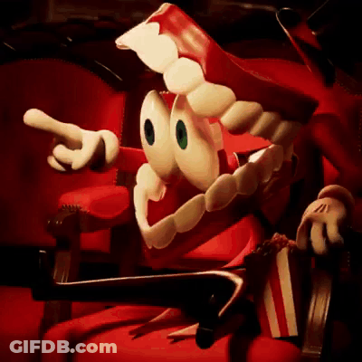 Cartoon Character In Red Chair Holding Popcorn And Pointing GIF