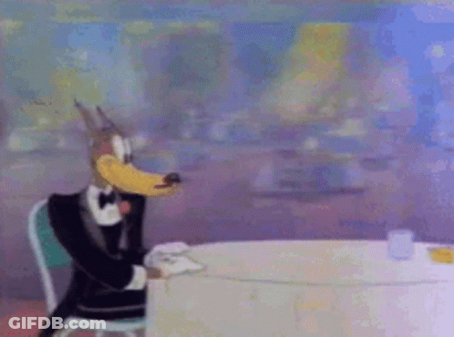 Cartoon Character In Tuxedo Sitting GIF