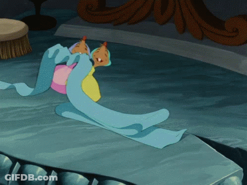 Cartoon Character Laying On Table With Blue Blanket GIF