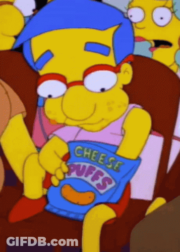 Cartoon Character Sitting In Chair Holding Cheese Puffs GIF