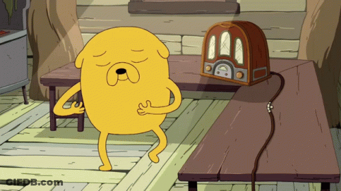Cartoon Character Standing Next To Radio On Wooden Table GIF