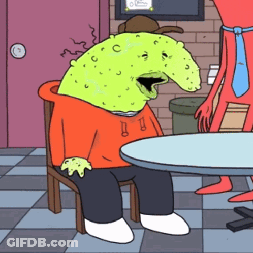 Cartoon Character With Green Head Sitting At Table GIF