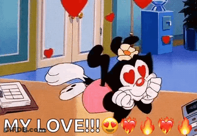 Cartoon Character With Heart Eyes Lying On Desk GIF