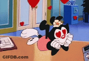 Cartoon Character With Hearts In Eyes Sitting On Pink Pillow GIF