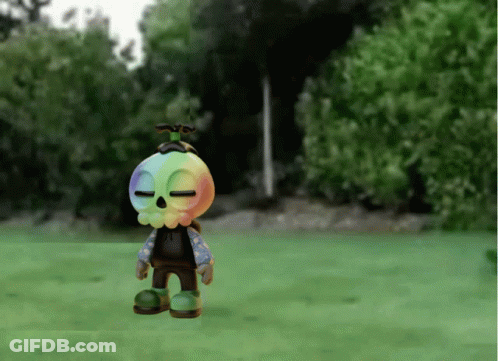 Cartoon Character With Rainbow Head Standing On Grass GIF