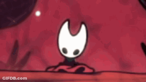 Cartoon Character With White Face And Black Eyes Sitting On Red Cloth GIF