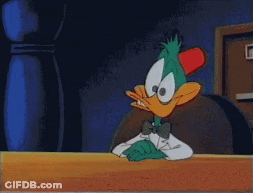 Cartoon Duck In Tuxedo Sitting At Table GIF