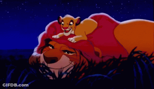 Cartoon Lion Laying Down With Cub On Head GIF