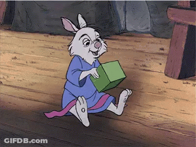 Cartoon Rabbit In Blue Robe Holding Green Block GIF