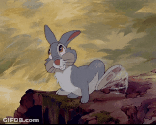 Cartoon Rabbit Sitting On Log Looking At Camera GIF