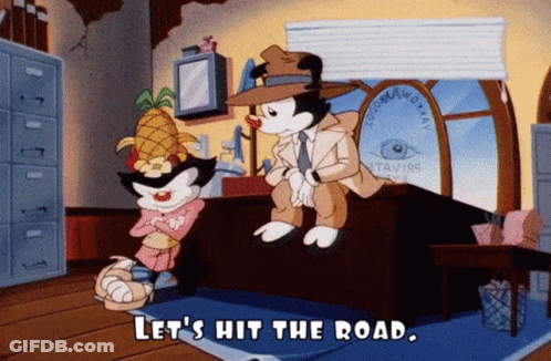 Cartoon Saying Let's Hit The Road Sitting On Desk GIF