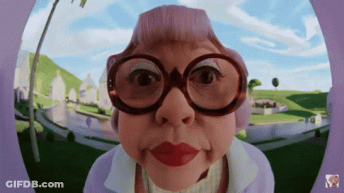 Cartoon Woman With Glasses And Purple Hat Looking At Camera GIF