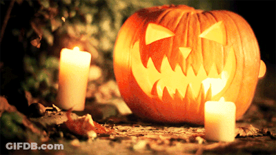 Carved Pumpkin With Two Lit Candles GIF