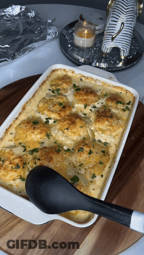 Casserole Dish With Black Spoon On Wooden Table GIF
