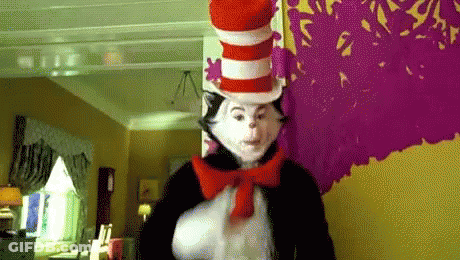 Cat In The Hat Standing By Purple Wall GIF