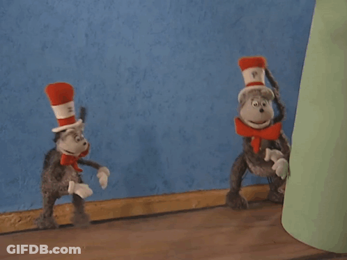 Cat In The Hat Standing Next To Stuffed Animal GIF