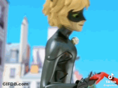 Cat Noir Standing In Front Of City Holding Red Object GIF