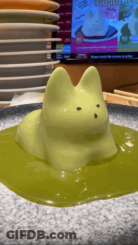 Cat Statue Sitting On Green Liquid GIF