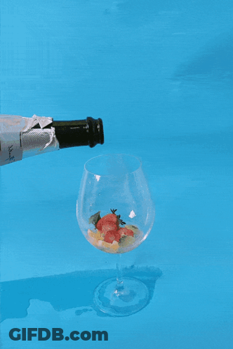 Champagne Poured Into Glass On Blue Surface GIF