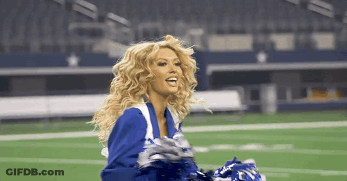 Cheerleader Holding Pom Poms On Football Field GIF