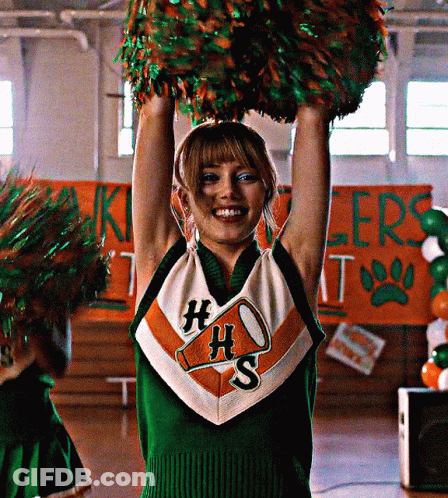 Cheerleader In HS Uniform Holding Pom Poms Above Head GIF