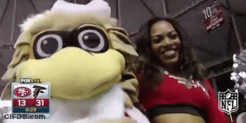 Cheerleader Posing With Mascot At Football Game GIF