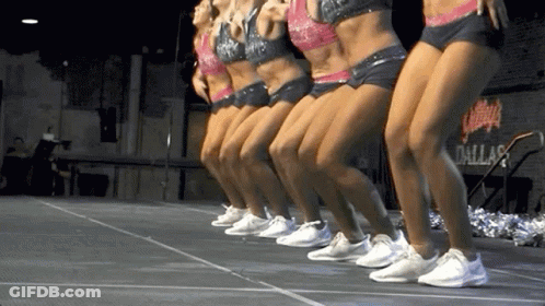Cheerleaders Dancing On Stage In Front Of Dallas Sign GIF